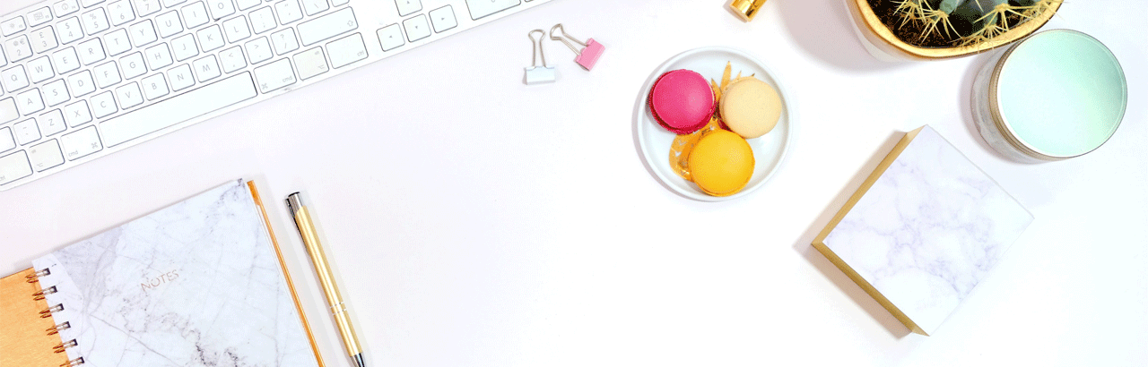 Clavier à côté d'un carnet de notes et des macarons